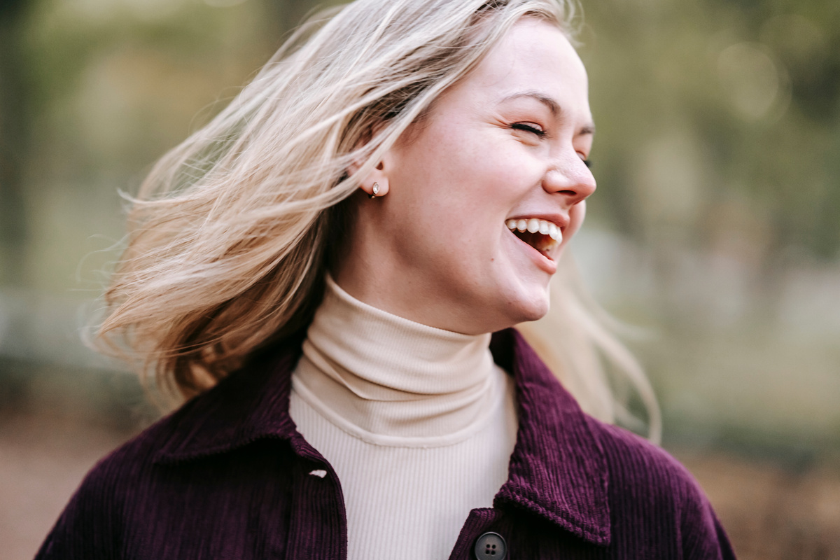 Happy woman in casual outfit laughing in park